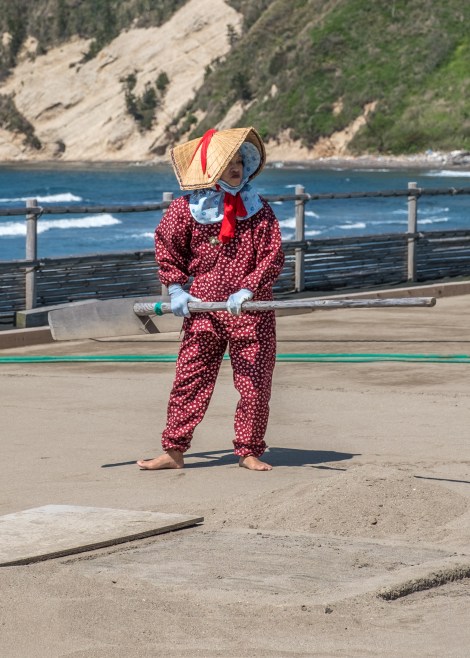 A lady moving sand to be turned into salt, Noto Peninsula